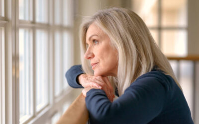 Frau blickt nachdenklich aus dem Fenster – Sinnbild für innere Leere und Sehnsucht nach Lebendigkeit